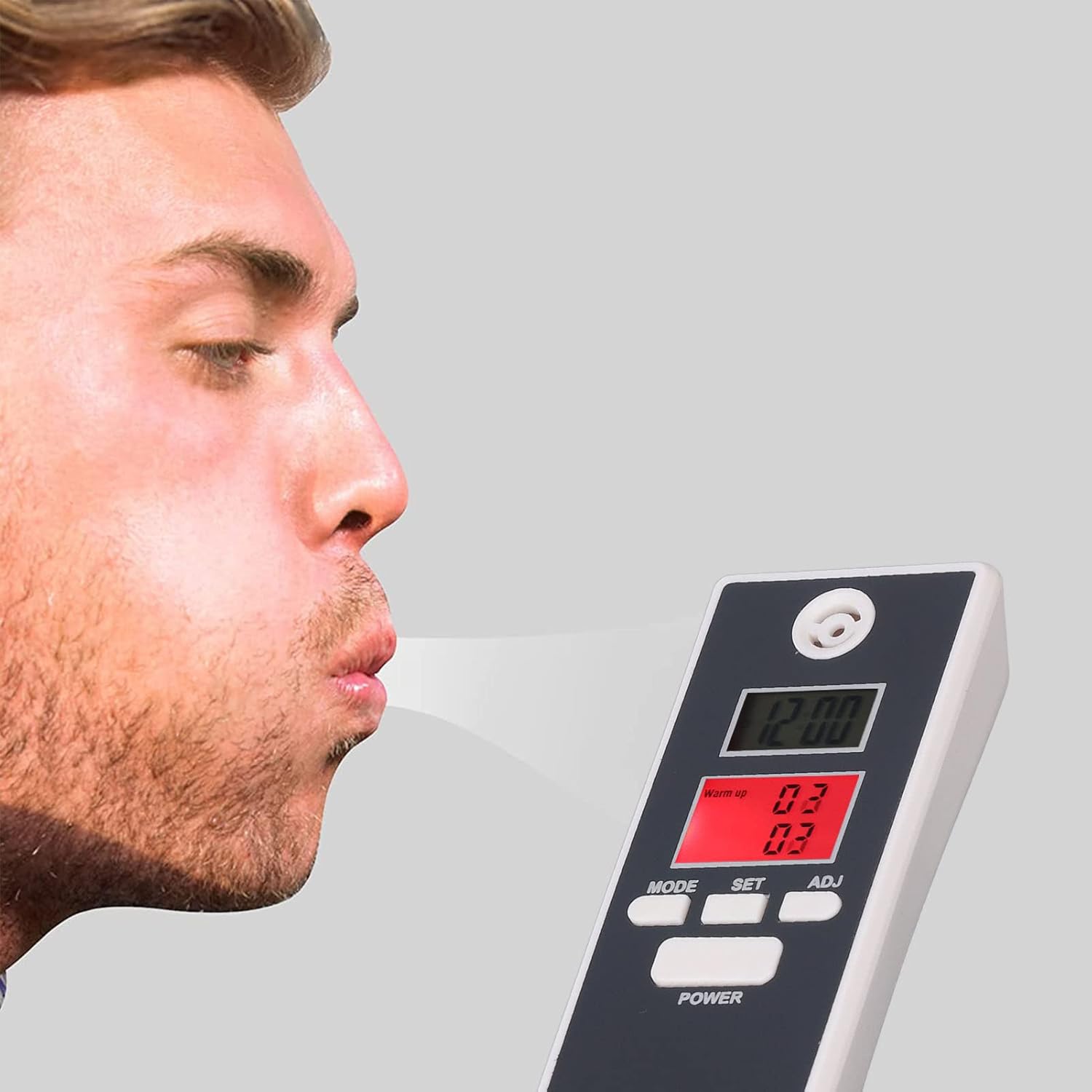 A person blowing into a digital breathalyzer device to test their blood alcohol content, with the device displaying readings on its screen.