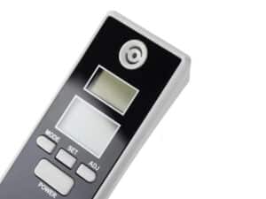 Digitální ruční alkohol tester s LCD displejem a tlačítky pro ovládání, určený k měření hladiny alkoholu v dechu.