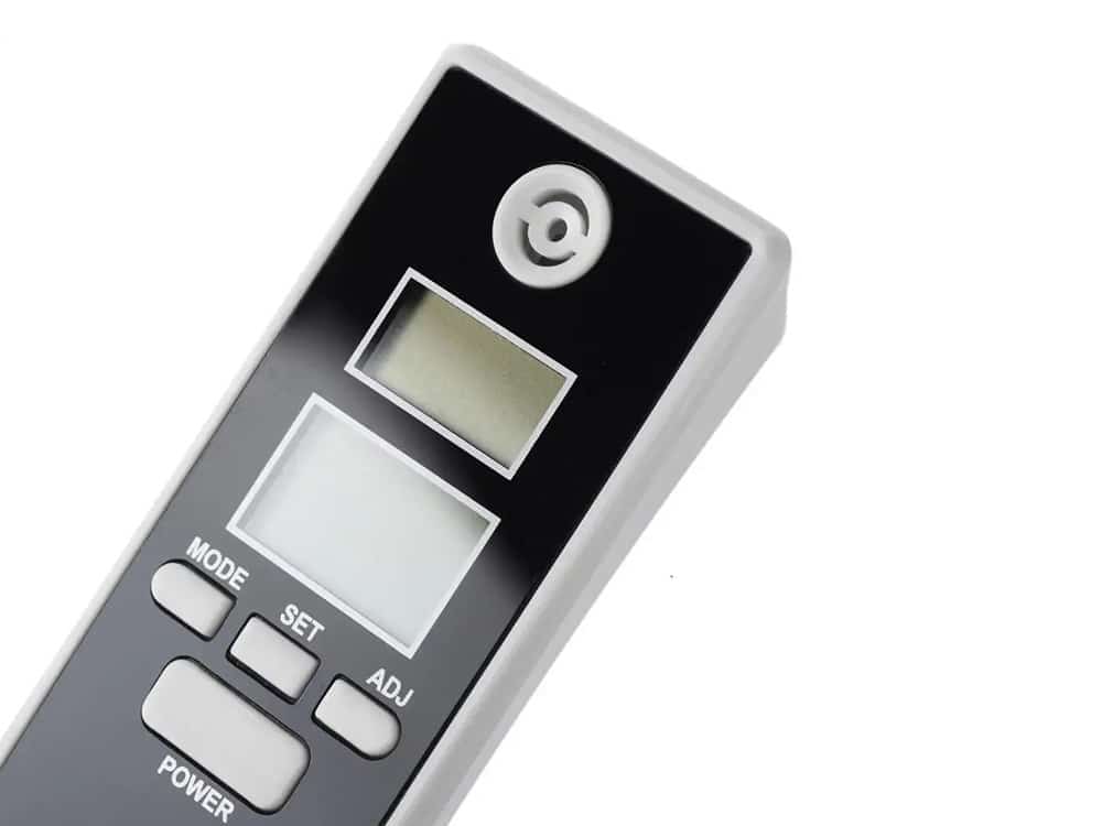 Digitální ruční alkohol tester s LCD displejem a tlačítky pro ovládání, určený k měření hladiny alkoholu v dechu.