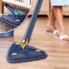 Trojúhelníkový mop s otočnou hlavou 360° určený pro snadné úklid rohů a obtížně dostupných míst, zobrazený na dřevěné podlaze s detailem jeho designu.