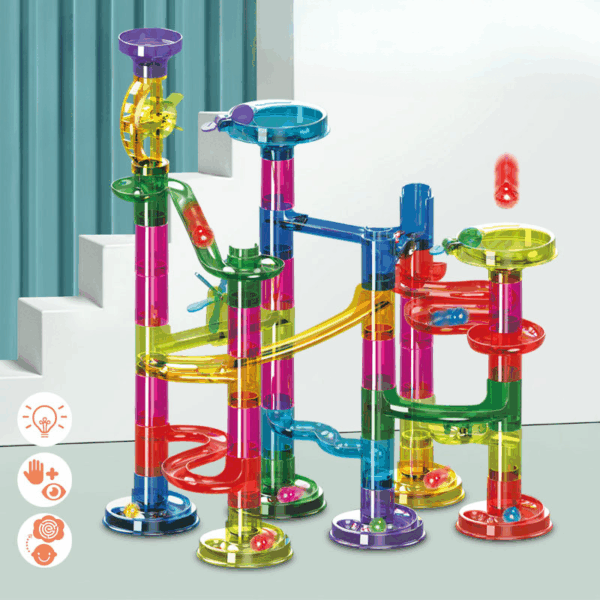 Barevná věž z plastových dílů určená pro marble run, skládající se z průhledných barevných trubek a drah, po kterých se pohybují malé kuličky v různých směrech.