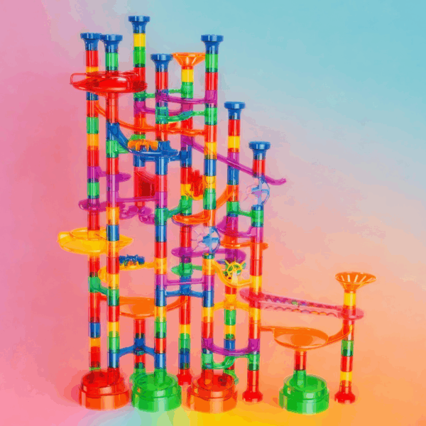 Barevná věž z plastových dílků mechanické kuličkové dráhy složené z různobarevných trubek, klesání a točen v duhovém barevném spektru.
