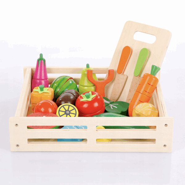 Dřevěný box s barevnými dětskými hračkami ve tvaru ovoce a zeleniny, včetně mrkve, rajčat, papriky a dalších druhů, s dřevěnou krájecí deskou.