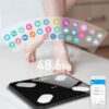 Digitální váha s černým povrchem s připojeným mobilním telefonem, zobrazující hmotnost 48,6 kg a barevné ikony zdravotních parametrů.