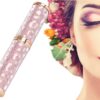 Luxusní kosmetická tuba v růžovém třpytivém designu vedle pózy ženy s makeup a květinovou dekorací, zaměřeno na beauty a módní doplněk.