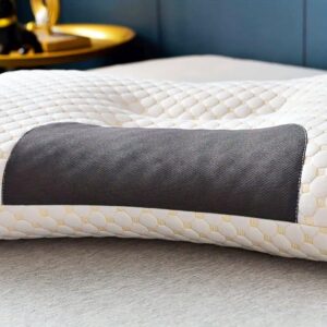 Ergonomický masážní polštář v šedo-bílém provedení, který je položený na měkkém povrchu a nabízí oporu a relaxaci pro krk a tělo.