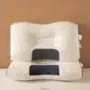 Ergonomický bílý polštář s černými kontrastními prvky, určený pro podporu krku a relaxaci, s prošívaným povrchem a měkkým vzhledem.