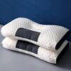 Ergonomický bílý polštář s černými detaily, s vroubkovanou texturou a speciálním designem pro podporu krku a relaxaci, určený pro pohodlné spaní a odpočinek.