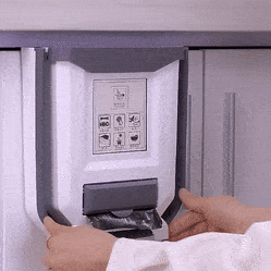 Ruce vkládají papír do elektrického rozřezávače dokumentů, který je namontován na zdi a slouží ke skartování citlivých materiálů.