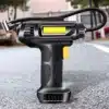Černý bezdrátový kompresor s ergonomickým designem a žlutými akcenty, určený pro pohodlné huštění pneumatik na cestách.