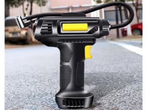 Čierny prenosný kompresor s žltými prvkami, určený na nafukovanie pneumatík, ktorý má ergonomický tvar pištole a flexibilnú hadicu.