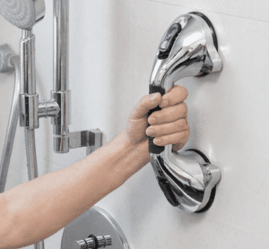 Stříbrné madlo v koupelně pro bezpečné uchopení, určené k podpoře stability a prevenci pádu při sprchování nebo pohybu ve vlhkém prostoru.