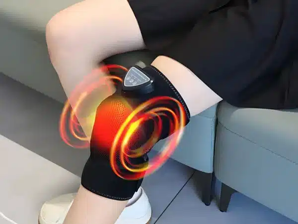 Černá termo-masážní kolenní bandáž s červeně znázorněným tepelným efektem, která poskytuje úlevu a podporu kloubu pomocí technologie zahřívání a masáže.