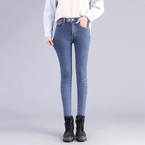 Modré džínové kalhoty ve střihu skinny s vysokým pasem, kombinované s černými šněrovacími botami na mohutné podrážce.