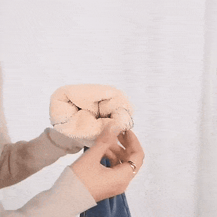 Dvě ruce v béžovém a modré rukavici svírají pěst, jedna ruka je položena na druhé v gestu solidarity nebo podpory.