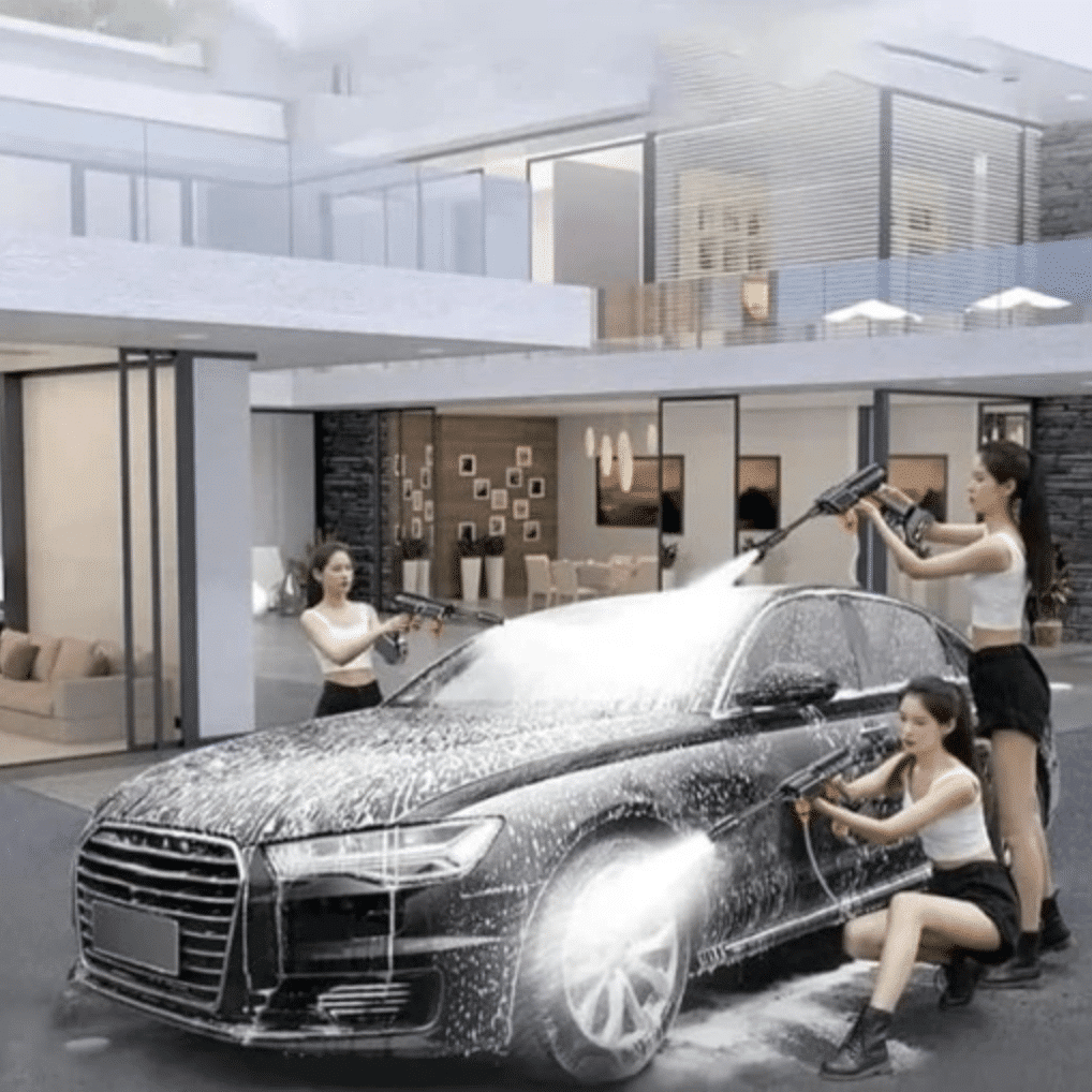 Tři ženy v bílém a černém oblečení myjí černé luxusní SUV vysokotlakou hadicí před moderním rodinným domem.