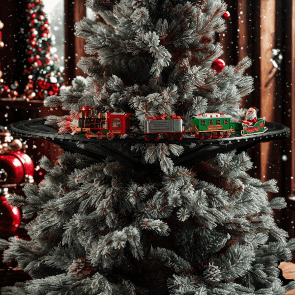 Vánoční stromek s zasněženými větvemi, na kterém je umístěná vánoční vláčková trať s lokomotivou, nákladním vagónem a Santa Clausem v zeleném vagónu, v pozadí jsou červené vánoční ozdoby a světýlka.
