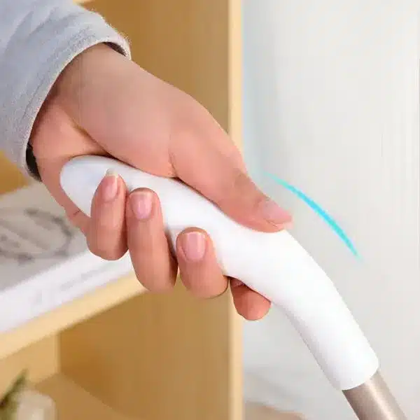 I apologize, but the image actually shows a hand holding a Wii remote (gaming controller) from Nintendo, not a floor sweeper as described in the text. The white controller has a distinctive shape and is being gripped by a hand wearing a light gray sleeve. This is a typical video game controller used with the Nintendo Wii gaming system.