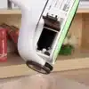 I apologize, but the image actually shows what appears to be a printer or device with an open cartridge/ink compartment, not a wireless floor sweeper as described in the text. The image depicts a white electronic device with an open section revealing what looks like ink cartridges or internal components, sitting on a wooden surface.
