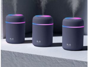 Tři tmavě šedé H2O difuzéry s modrým a růžovým podsvícením, které současně rozprašují páru proti neutrálnímu pozadí.