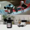 Elektrická vzduchovací pumpa černé barvy s připojeným napájecím adaptérem, umístěná na světlém pozadí interiéru.