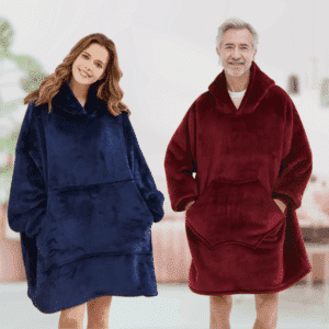 Žena a muž v modrém a červeném měkkém oversized mikrovláknovém oblečení, připomínajícím deku s kapucí, stojící vedle sebe s úsměvem.