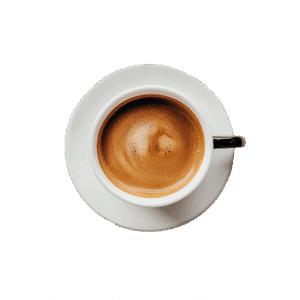 Pohled shora na šálek čerstvé espresso s hustou pěnou v bílém šálku na bílém podšálku.