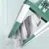 Zelená čistička tekutinou promývaná s bílým filtrem, zachycující proud vody a částečně zachycený filtrační materiál.