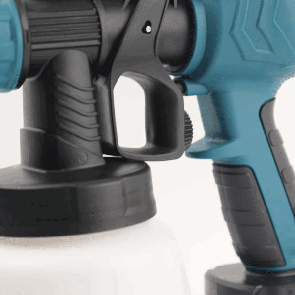 Modrý a černý průmyslový stříkací pistolový přístroj, detail na rukojeť a spoušť elektrického nářadí určeného pro lakování nebo nástřik barev.