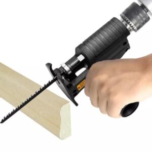 Ruční elektrická pila (ocaska) při řezání dřevěného materiálu, detail na černou rukověť a řezací nástroj v akci.