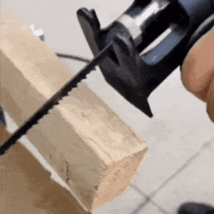 Ruční elektrická pila řezající dřevěný hranol na bílém pozadí, detail nástroje a řezné hrany.
