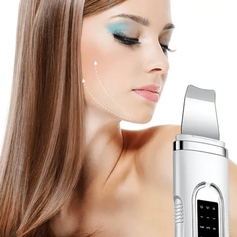 Žena s kreativním modrým líčením očí drží v ruce moderní kosmetický přístroj, který je zřejmě určen pro péči o pleť s vyznačenou konturou obličeje.