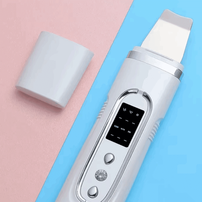 Bílý ultrazvukový čistič pleti s digitálním displejem a příslušenstvím na barevném modro-růžovém pozadí.